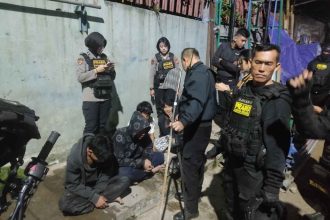 teenagers are detained by police officers