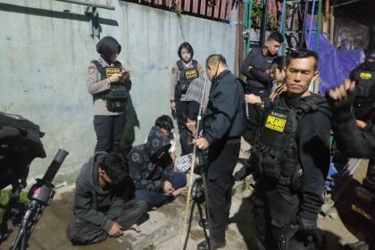 teenagers are detained by police officers