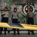 Police officers stand guard