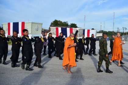 Military officials carry the coffins of soldiers