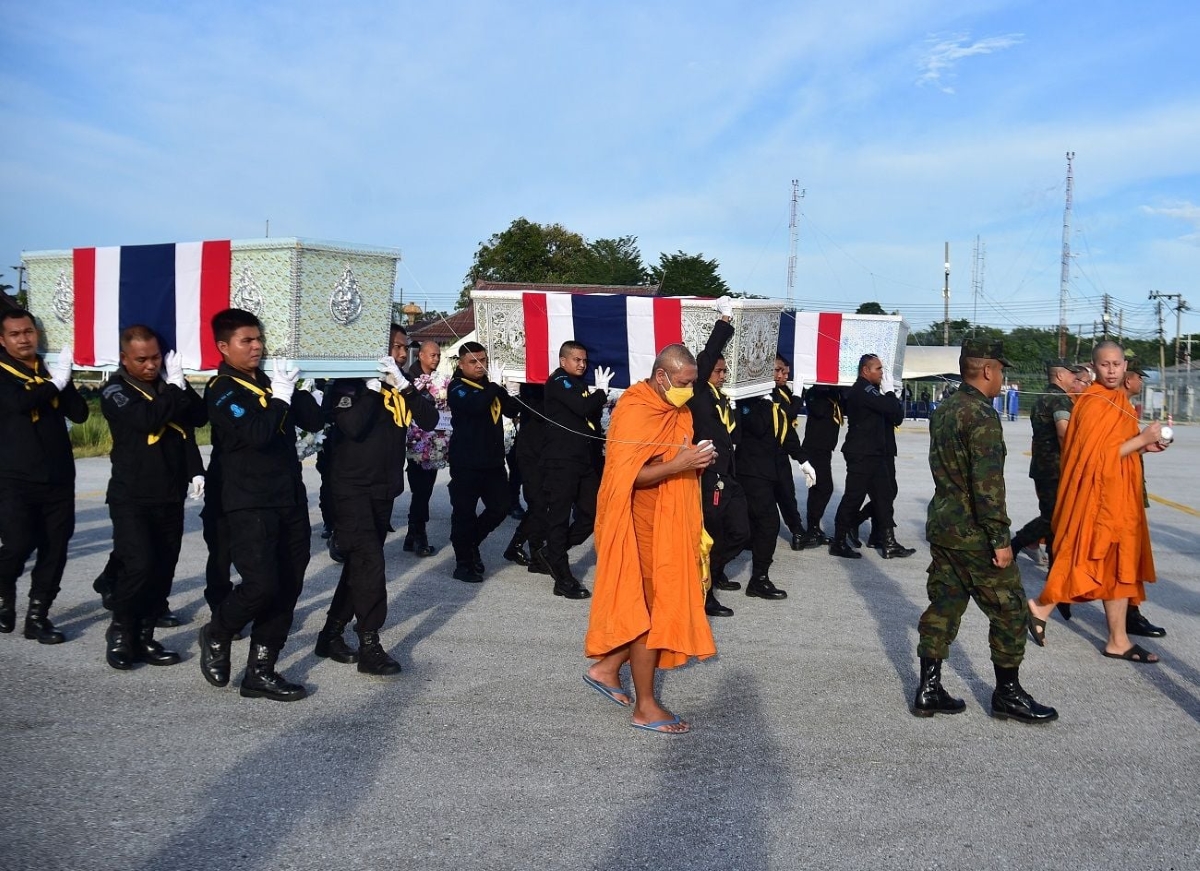 Military officials carry the coffins of soldiers